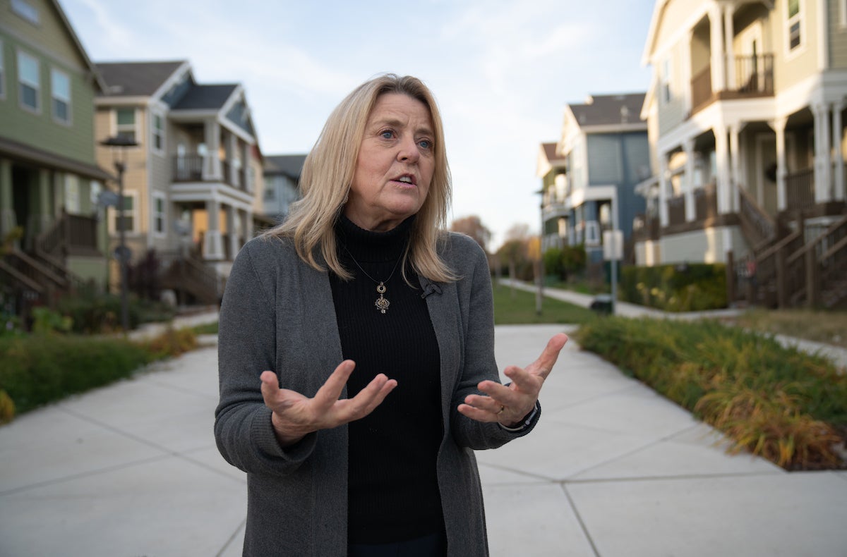 Kathleen Schaefer of ˽̳ Davis talks in front of elevated houses