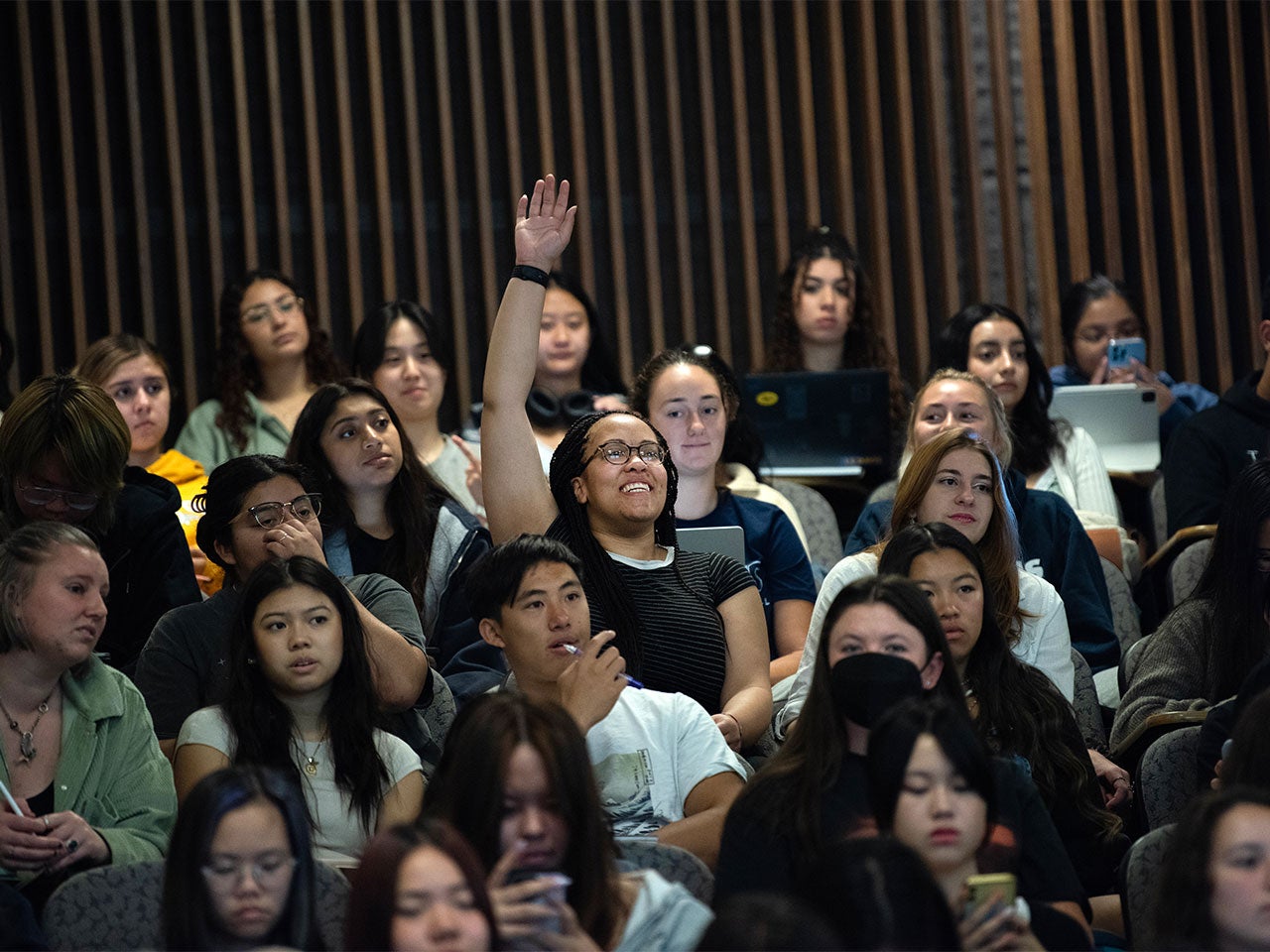 A ˽̳ Davis student raises their hand during a class session.