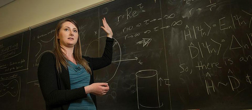 Rachel stands in front of a chalkboard while lecturing at ˽̳ Davis