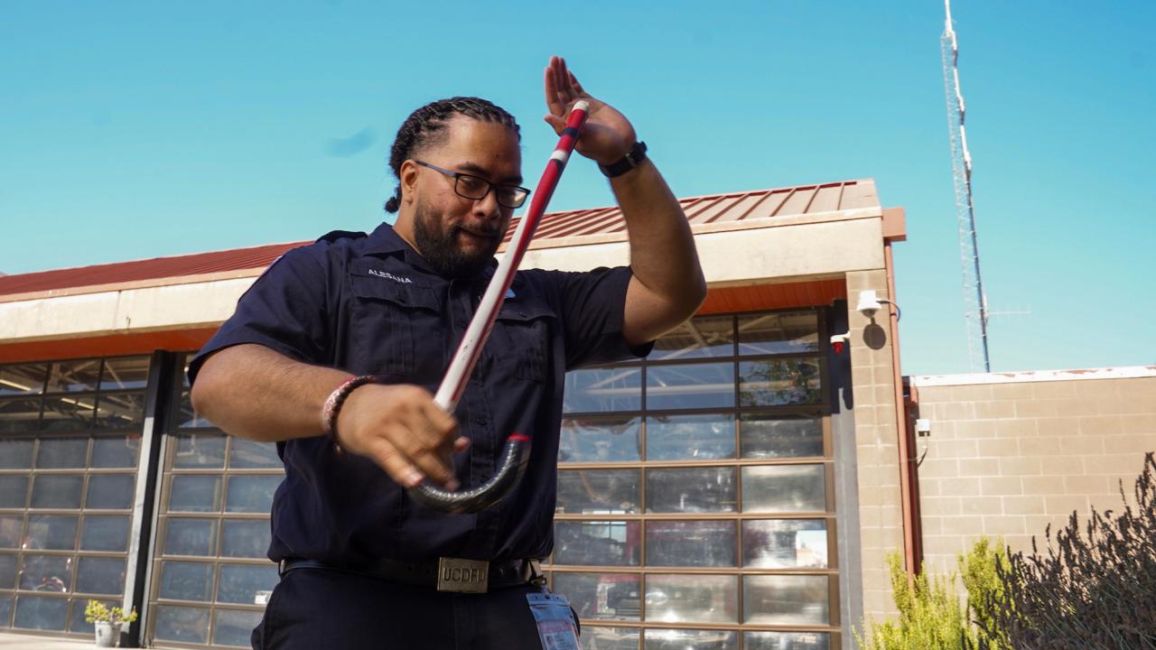 Abiel Malepeai with his fraternity cane outside the ˽̳ Davis Fire Department.