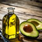 A ˽̳ Davis study finds most private label avocado oils are either rancid or adulterated. No enforceable standards for avocado oil exist yet. Pictured here is a bottle of avocado oil and spoon next to a cut avocado. (Getty Images)