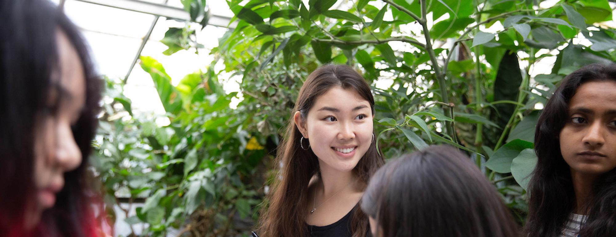 Students smile in a botanical garden at ˽̳ Davis. 